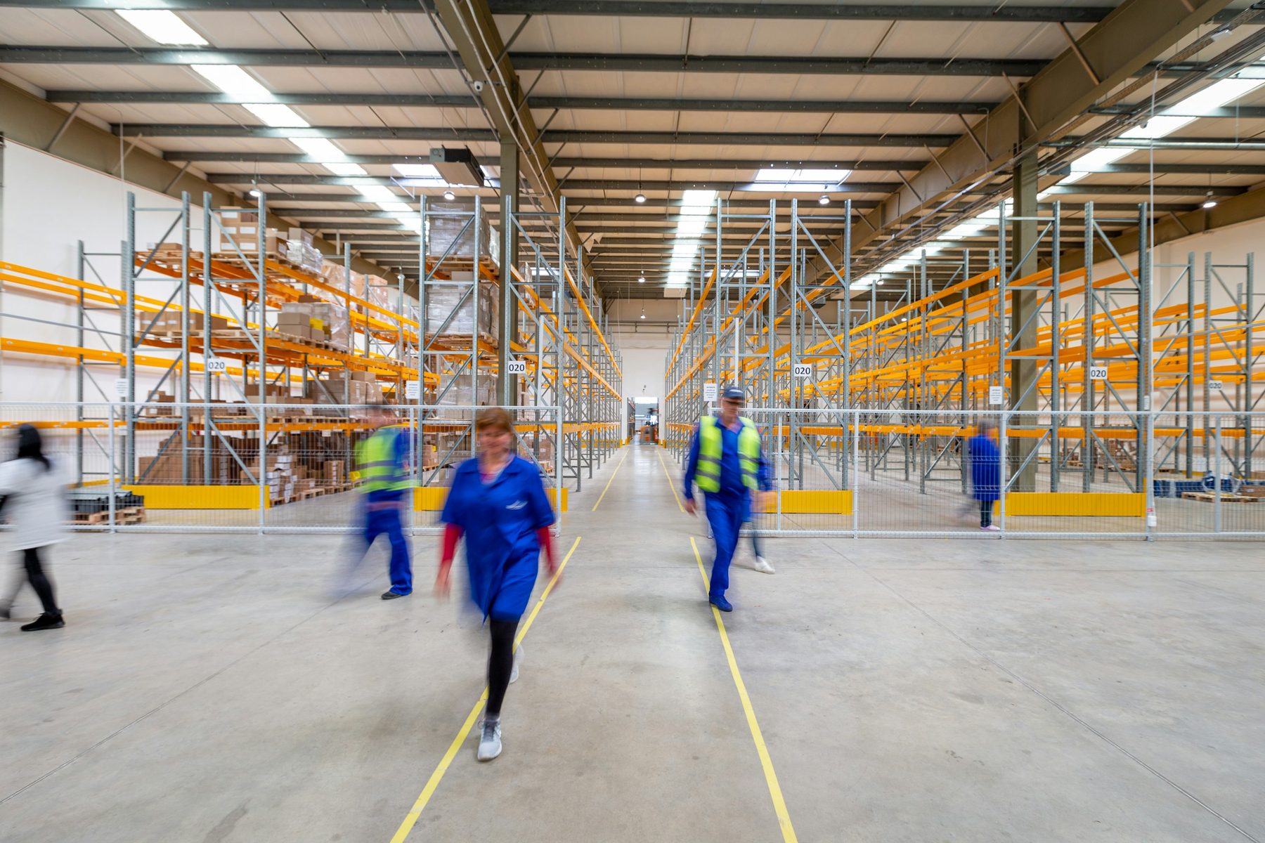 Operarios trabajando en el pasillo de un almacén logístico